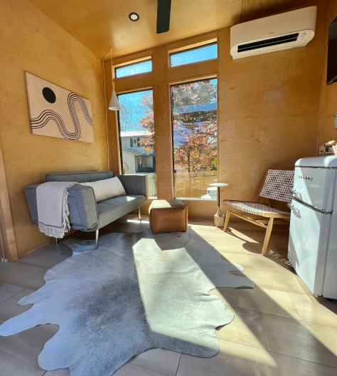 Beautiful interior of tiny home with light shining through windows.